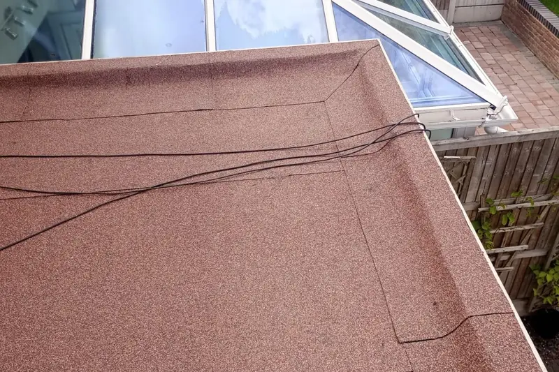 Red mineral felt flat roof finished around a conservatory in Halesowen