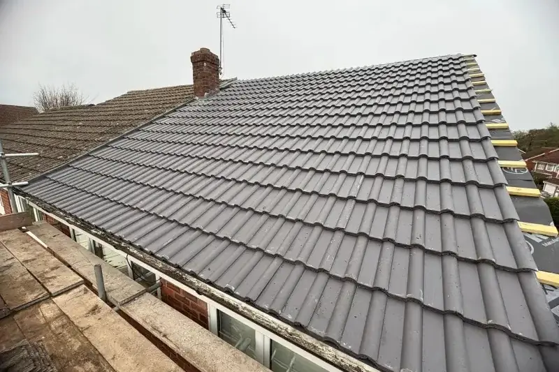Finished grey tiled roof with new gutters on a Birmingham home