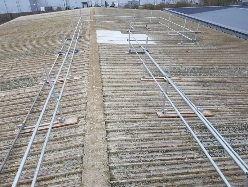 Safety rails on a large industrial roof during a storm damage repair in Coventry